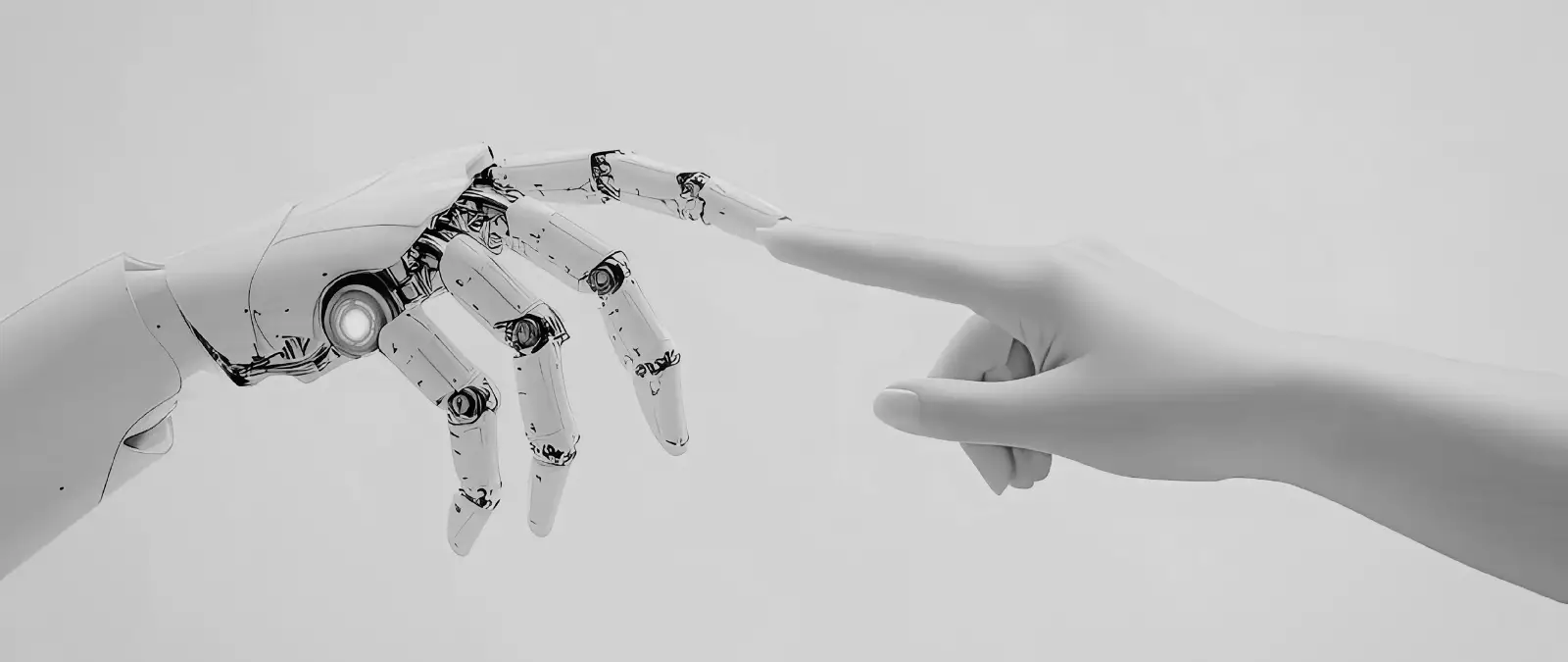 A robotic hand and a human hand reach towards each other, with their index fingers nearly touching against a neutral background, symbolising the connection between technology and humanity.