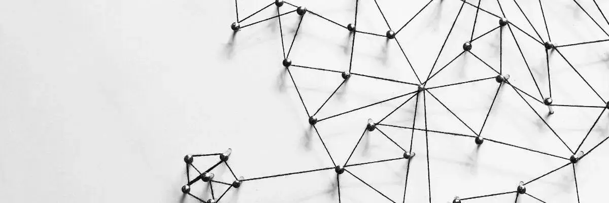 Black strings connected by pins form an abstract network pattern on a white background, with most connections clustered on the right and a small isolated cluster on the left.