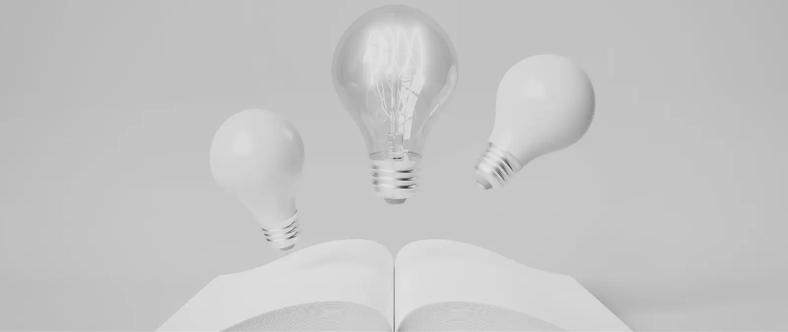 Three light bulbs, one lit and two unlit, appear to float above an open book, symbolising creativity and ideas emerging from reading or learning—much like the spark of insight that drives effective entity SEO. The background and tones are monochromatic.