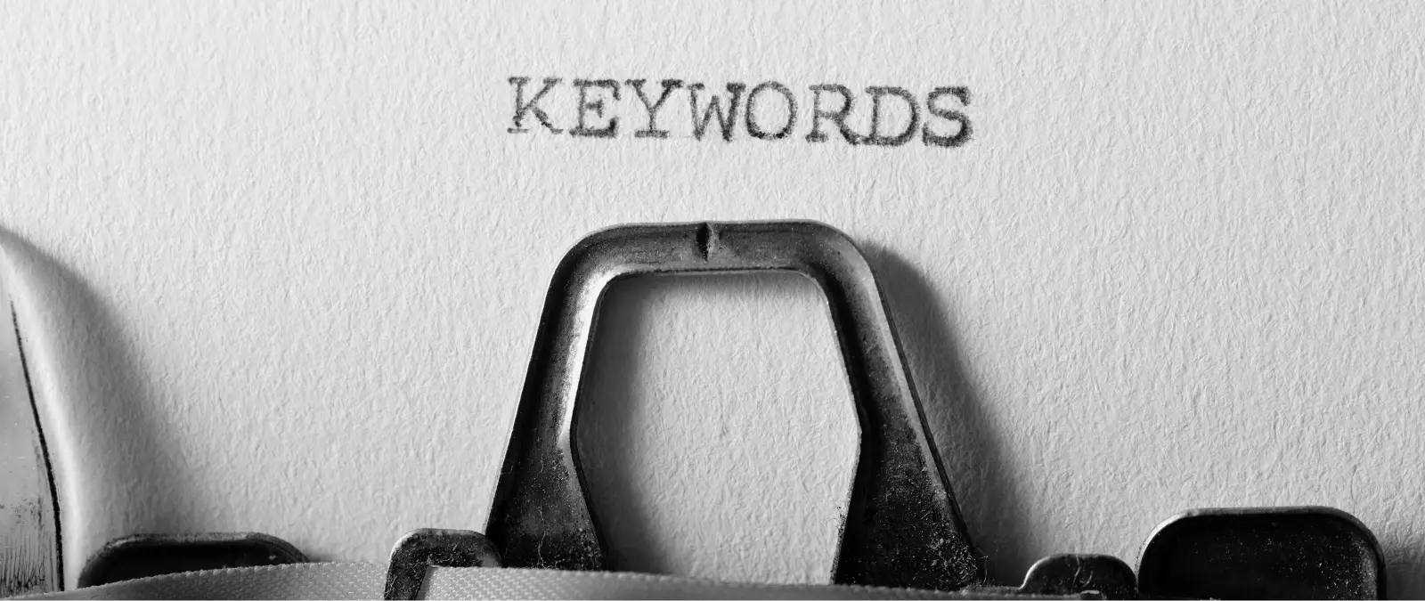 The phrase How topic clusters boost SEO is typed in uppercase on white paper with a typewriter, featuring part of the typewriter mechanism visible at the bottom of the image.