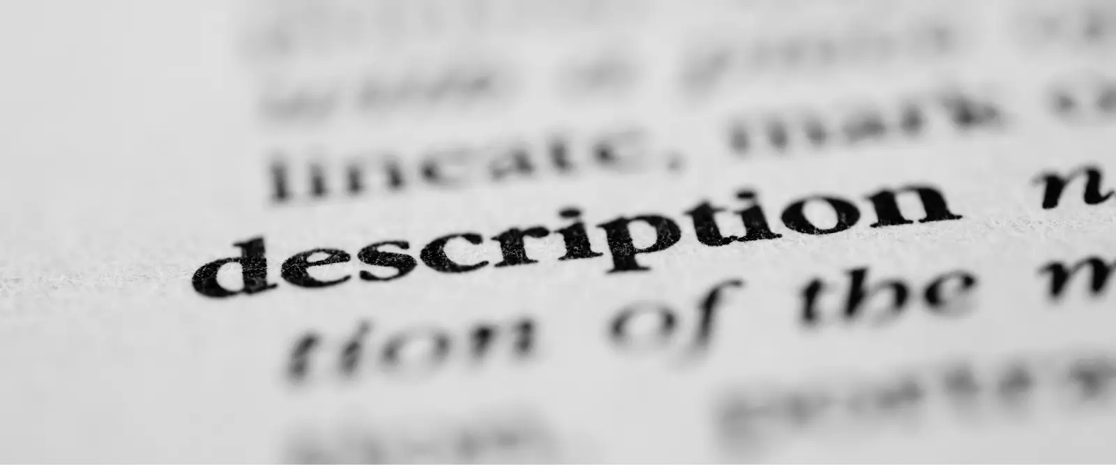 A close-up of the word description printed in bold black text on a white page, with the background words blurred, illustrating the clarity and focus essential for effective on-page SEO optimisation.