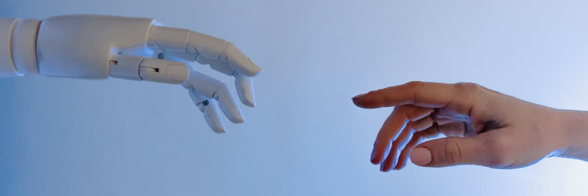 A hand reaching out to touch a robotic hand.